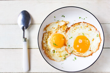 a plate of fried eggs on a wooden table