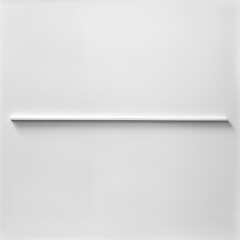 A white wall with a long, thin, silver object on it