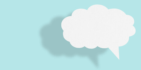 Empty white cloud paper speech bubble shape against light blue background.