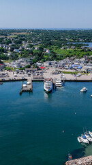 Obraz premium New Shoreham, RI, USA - August 5 2024: Vertical aerial image of Old Harbor, Block Island, New Shoreham, RI and local downtown area and ferry terminal. 