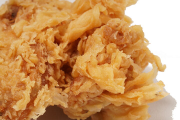 Golden fried chicken with a crispy, flour-coated skin, photographed against a white background.