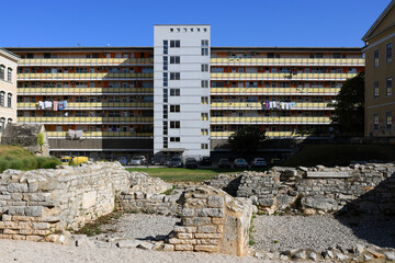 Modern residental building with ancient Roman ruins in the foreground in Pula, Croatia