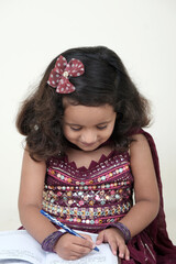  A delightful little girl with sparkling eyes, breaking into a wide, infectious smile. Her expression radiates pure happiness and innocence.