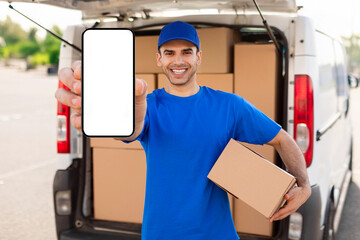 Delivery service app concept. Courier man in blue t-shirt uniform holding cardboard box and showing...