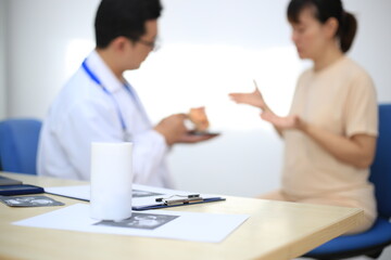 Obraz premium Male doctor with experience examining young pregnant women