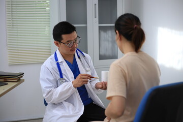 Obraz premium Male doctor with experience examining young pregnant women