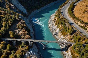 Aerial view the blue water of Rakaia river flowing through the gorge rock face walls under the road bridge