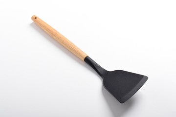 Kitchen spatula on isolated white background. Black silicone spatula with wooden handle. Cooking utensil