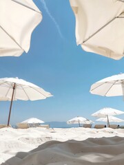 A serene beach scene under a clear blue sky. The beach is dotted with white umbrellas providing shade to the beachgoers. Italian beach