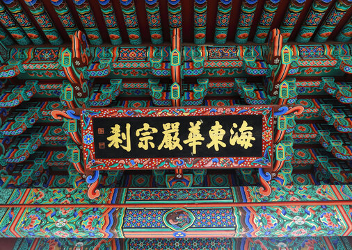 Yeongju-si, Gyeongsangbuk-do, South Korea - June 14, 2022: Low angle view of Dancheong(multicolored paintwork) and sign board Hae Dong Hwa Eom Jong Chal on the eaves of Buseoksa Temple