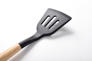 Close up Kitchen spatula on isolated white background. Black silicone spatula with wooden handle. Cooking utensil