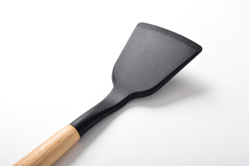 Close up Kitchen spatula on isolated white background. Black silicone spatula with wooden handle. Cooking utensil