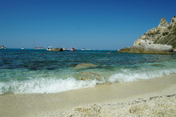 A summer day on the Mediterranean, where the water is so clear that boats seem to float above it. The blue of the sea is striking in its purity, and you can see every pebble through the water.