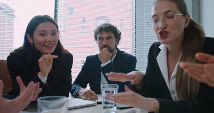 Diverse, group of people arguing during important meeting. Man in middle sitting silently and spectating. Problems at company. Difficult decision. People not agreeing. Problems in office.