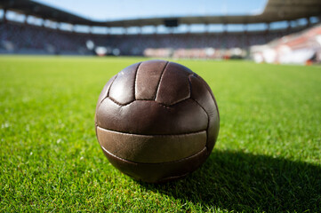 Old soccer ball on the grass at the stadium