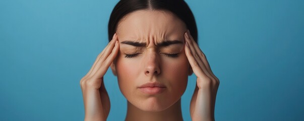 Obraz premium Portrait of Woman Suffering from Migraine, Clutching Temples in Pain, Copy Space for Text.