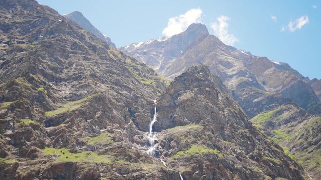 4K shot of waterfall in the Himalayan mountain ranges as seen from Tandi village in Pattan valley at Lahaul and Spiti district, Himachal Pradesh, India. Waterfall due to melting of glacier in summer.