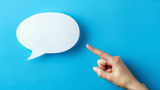Female hand pointing at empty white speech bubble on blue background, blank space banner for message insertion