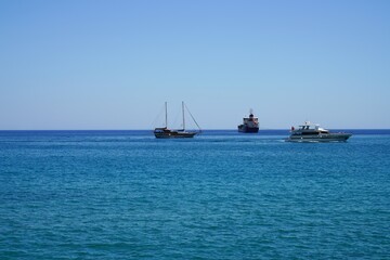 ships and a boat on the horizon at sea