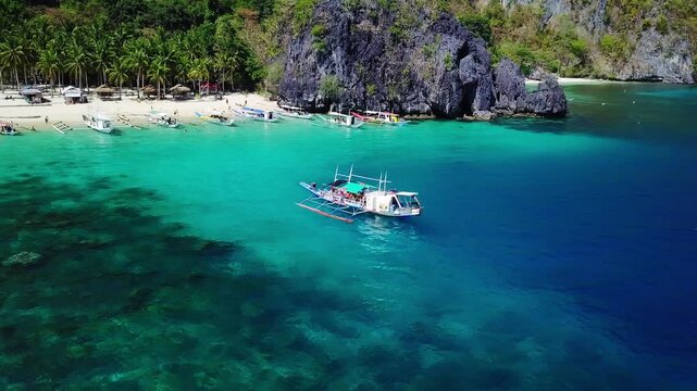Aerial view of traditional filipino boat sailing in Seven Commandos beach, Palawan, Philippines. 