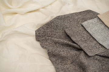 Fototapeta premium Gray textured fabric for curtains close-up. Tissue samples on a milky background.