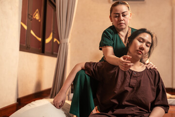Asian woman customer received service Thai massage with professional masseur. Body massage of shoulder for treat painful from office syndrome. Thai massage body with masseur.