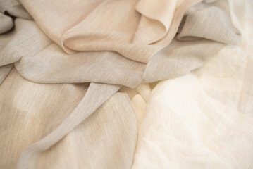 Light, milky color, transparent fabric for curtains close-up. Folds of light tissue.