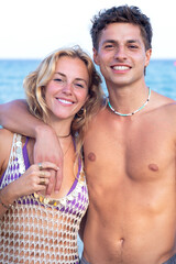 Vertical portrait two young friends on the beach looking at the camera