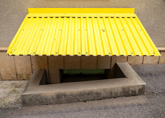 Canopy made of corrugated sheet metal over the basement window