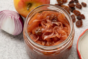 Glass jar with apple onion chutney with raisins close up