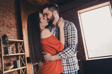 Photo of attractive trendy cheerful married young couple hugging kissing spending free time move new apartment home interior indoors