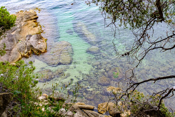 Beautiful beach scene in Costa Brava with transparent quiet water sin the shore of a sandy beach