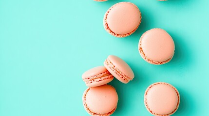 Obraz premium Delicious seamless pink macarons scattered on a vibrant turquoise background for a whimsical and minimalistic presentation
