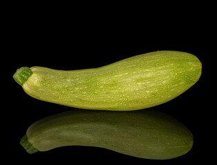 One ripe zucchini, macro, isolated on black background.