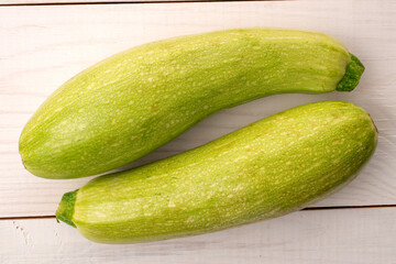 Two ripe zucchini  on a wooden table, macro, top view.