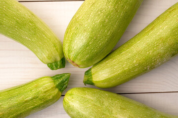 Several ripe zucchini on a wooden table, macro, top view.