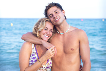 Smiling multiethnic woman and man enjoying vacation. Beautiful and cheerful couple of generation z pose for a photo with a mobile phone.