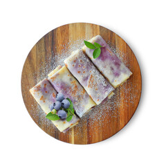Crepes, thin pancakes with blueberry filling on round wooden board isolated on white background top...