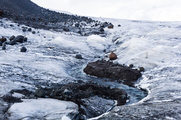 streams of water on the surface of a melting high-mountain glacier
