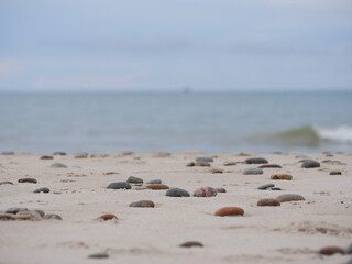 Seascape under a cloudy sky. Skagerrak, Kattegat strait in Skagen, Denmark. Stones on the sand at the foreground