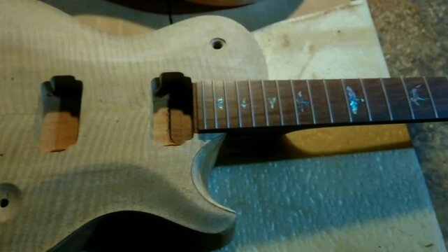 4k Closeup natural mango wood top body, rosewood fretboard electric guitar unfinished yet.