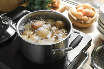 Boiling potatoes in pot on stove in kitchen