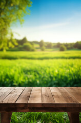 Fototapeta premium Wooden table on grass field under a sunny sky with natural surroundings, including trees and open space, evoking a summer or spring picnic atmosphere
