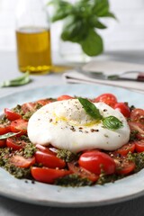 Fresh delicious burrata salad served on table, closeup