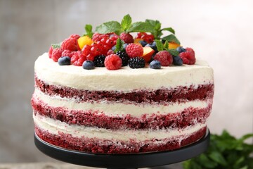 Tasty sponge cake with different fruits and mint on blurred background, closeup