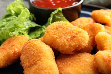 Tasty crispy chicken nuggets on table, closeup
