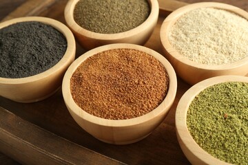 Different superfood powders in bowls on table, closeup