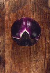 purple and white eggplant, spherical shape, on a wooden board, top view, raw eggplant, no people,