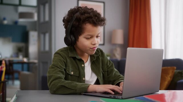 African American little son boy baby child kid gamer user at home in headphone earphone playing online video game play internet addiction computer laptop gaming listening music entertainment addict