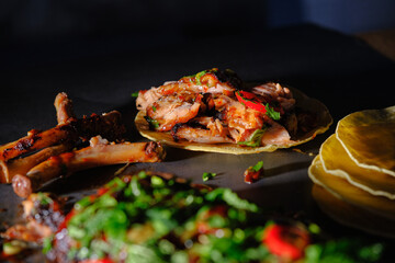 Delicious rib tacos with spicy toppings on a dark background